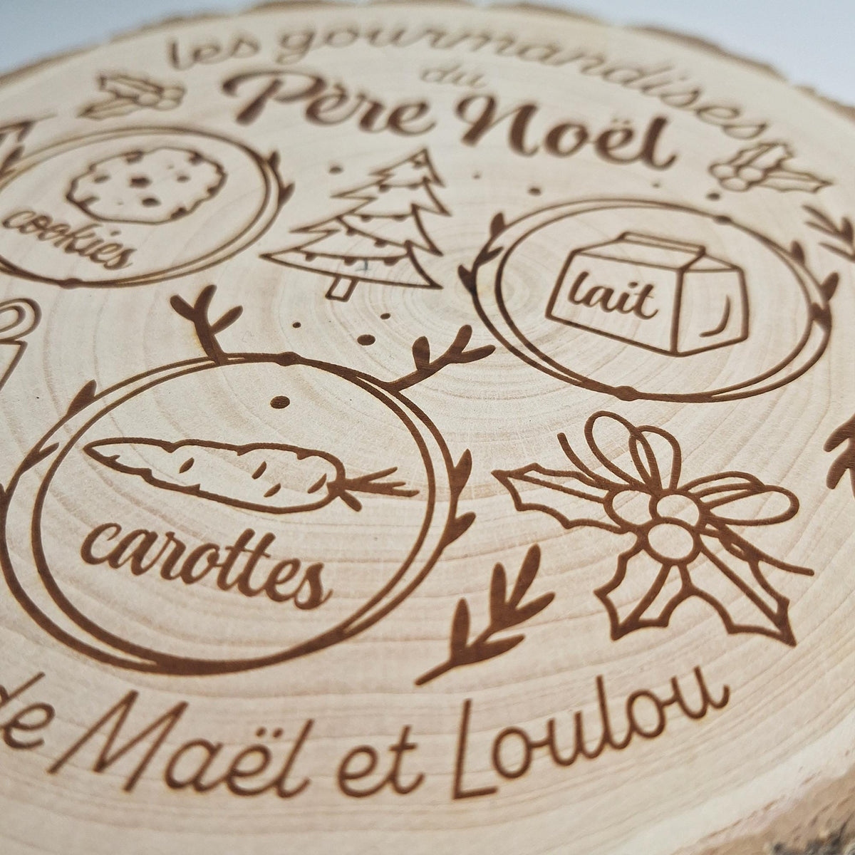 Gros plan sur les gravures « carottes » et « lait » du plateau du Père Noël
