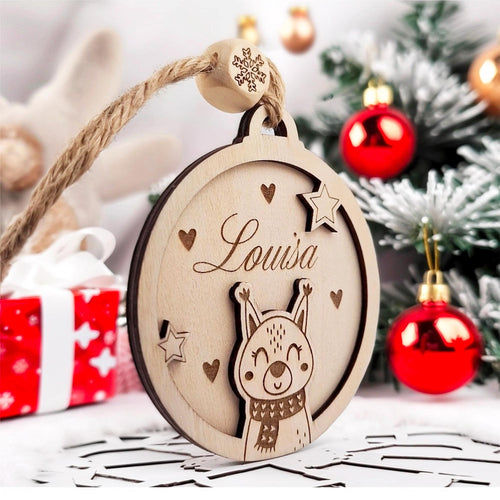 Boule de Noël en bois au prénom Louisa et écureuil devant des cadeaux