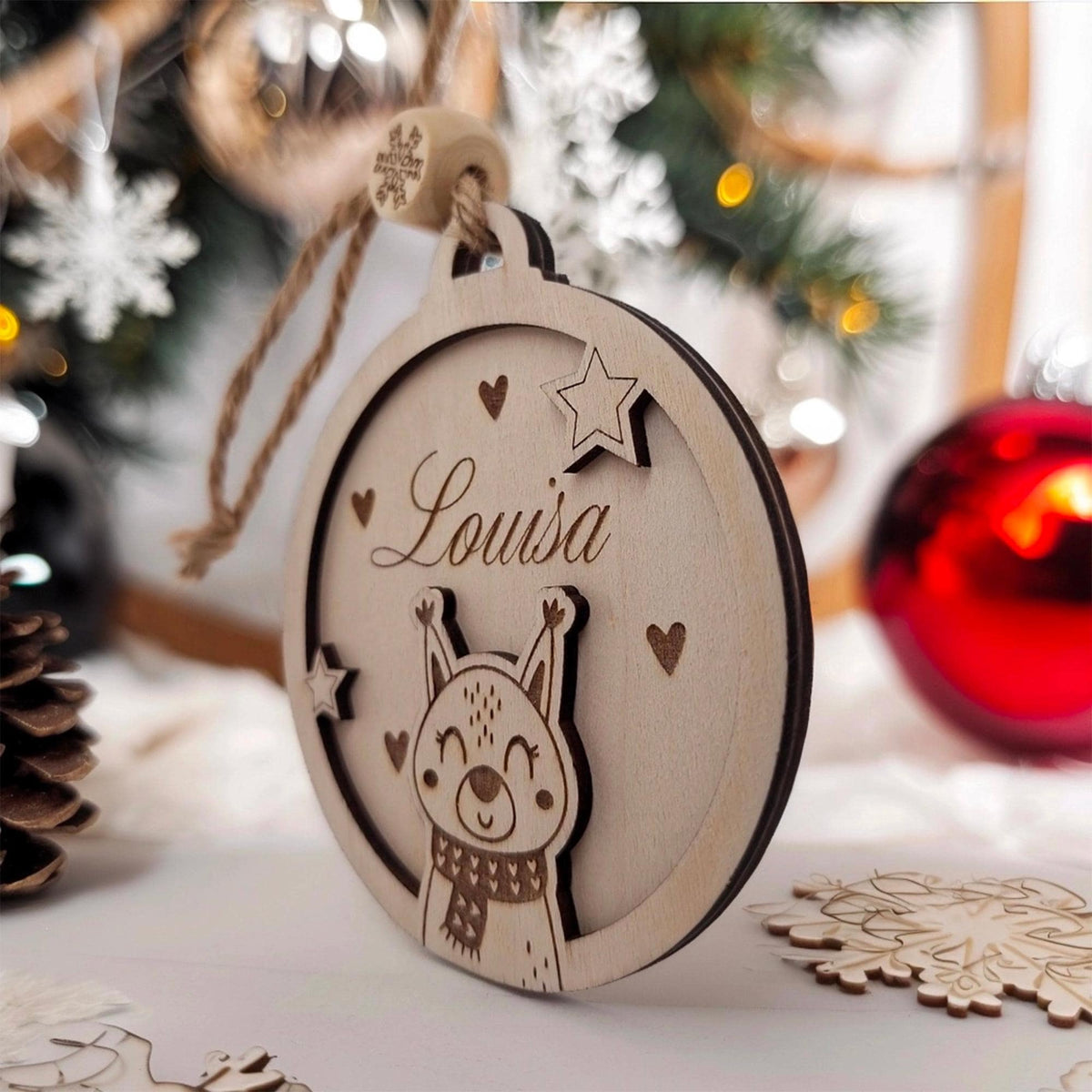 Boule de Noël en bois écureuil Louisa près du sapin